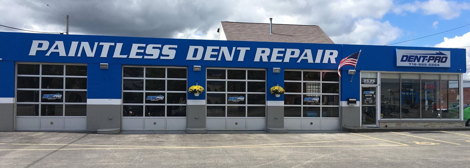 Dent-Pro Paintless Dent Repair shop building with blue walls and garage bays
