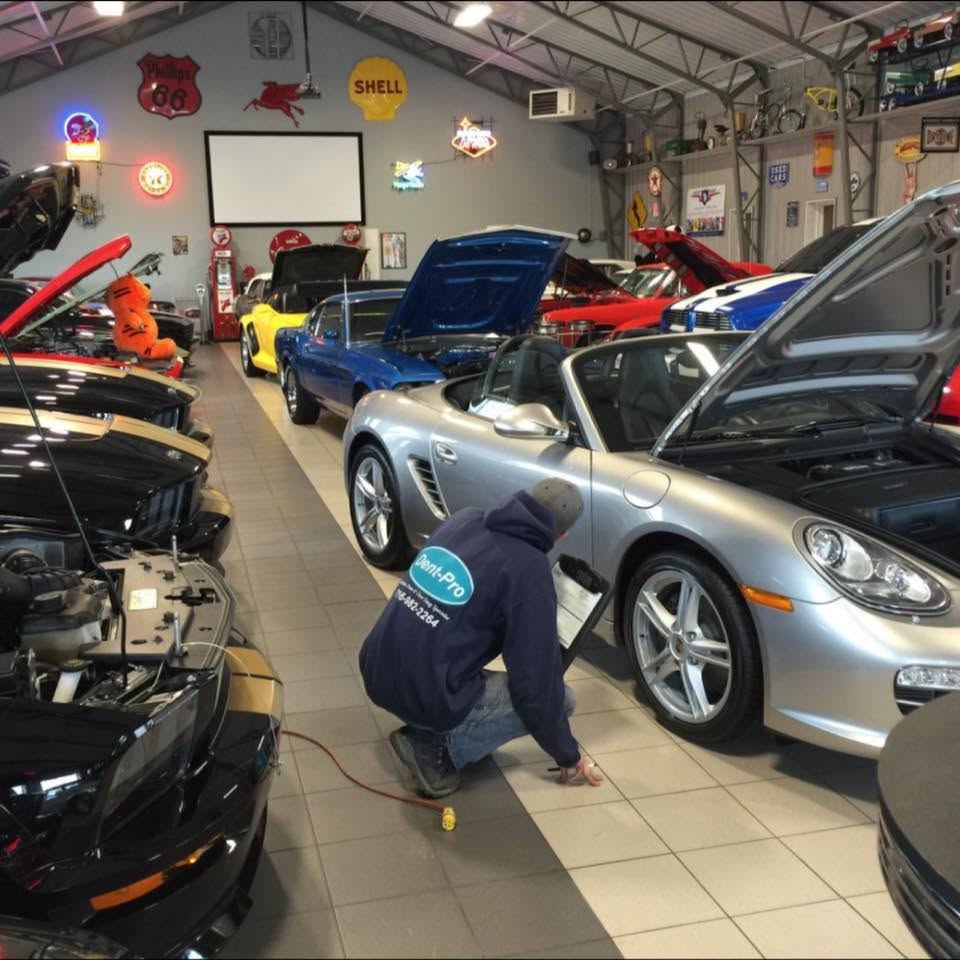 Tyler Cooper of Dent-Pro performing paintless dent repair on a silver Porsche Boxster